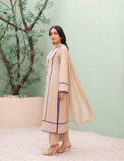 Woman in a beige traditional outfit with a light green background